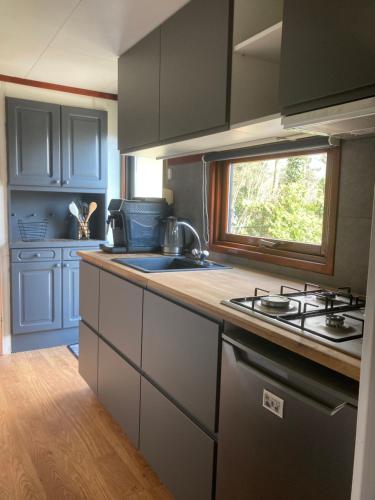 a kitchen with a sink and a stove in it at Welcome, relax and enjoy your stay in Putten