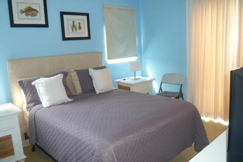 a bedroom with a purple bed and a blue wall at The blue lagoon of the Caribbean Sea. Velero 205.Cadaques Caribe in La Fragata