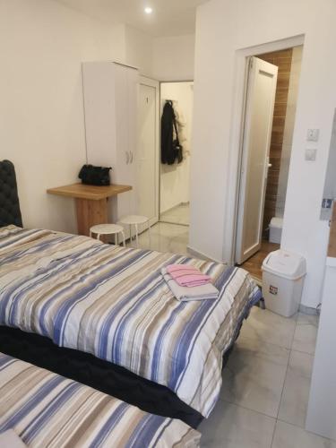 a bedroom with a bed with a striped blanket at Apartman Aleksandar 2 in Ribarska Banja