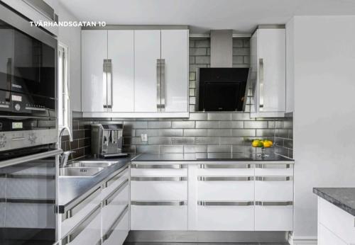 布羅斯的住宿－Stort hus uthyres med utegård gräsmatta，白色的厨房配有白色橱柜和水槽