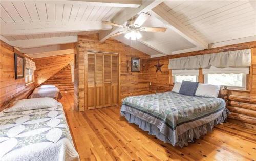 BuffaloにあるDragonfly Meadows Log Cabinのベッドルーム1室(ベッド2台、シーリングファン付)