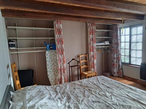 une chambre avec un grand lit et une fenêtre dans l'établissement Le walnoot, à Arnèke