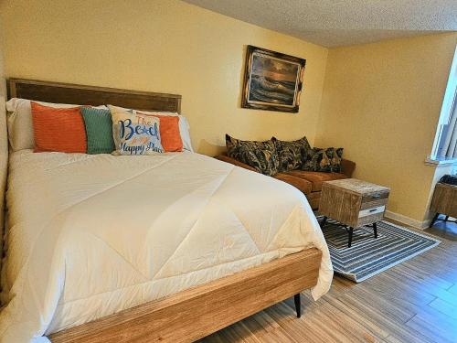 a bedroom with a large bed with colorful pillows at Oceanfront Escape With Balcony and heated salt water pool! in Daytona Beach