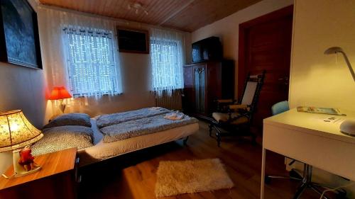 a bedroom with a bed and a desk and two windows at Travelling Sun in Give