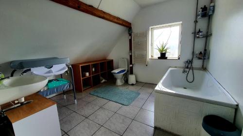 uma casa de banho com um lavatório, uma banheira e um WC. em Travelling Sun em Give