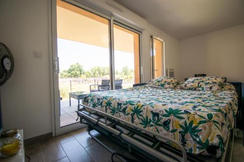 une chambre avec un lit et une grande fenêtre dans l'établissement studio avec jardin, piscine et parking, à Aix-en-Provence