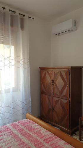 a bedroom with a bed and a dresser and a window at Bingo 1 completo in Alghero