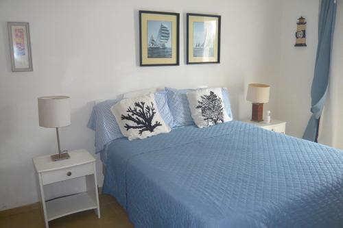 een slaapkamer met een blauw bed met 2 kussens bij Cadaques Caribe Boulevard Dominicus Americanus Carretera a Bayahibe Vel 206 in Bayahibe