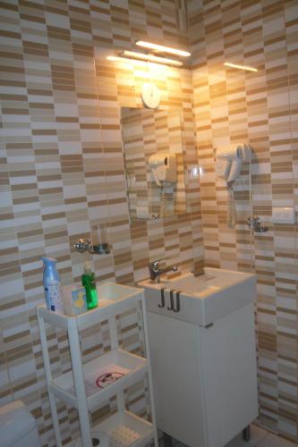 a bathroom with a sink and a mirror and a stool at Cadaques Caribe Boulevard Dominicus Americanus Carretera a Bayahibe Vel 206 in Bayahibe