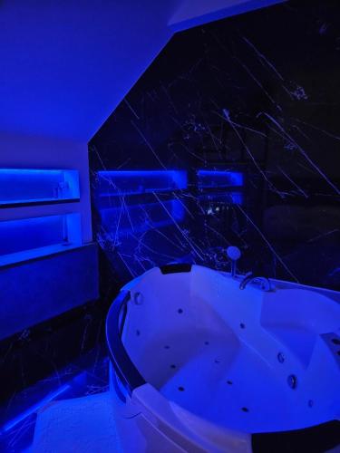 a bathroom with a white tub and blue lighting at Delux apartman President Centar in Brčko