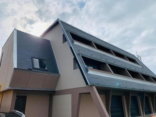 a building with a metal roof on top of it at Côte et mer (Blériot-plage) in Sangatte