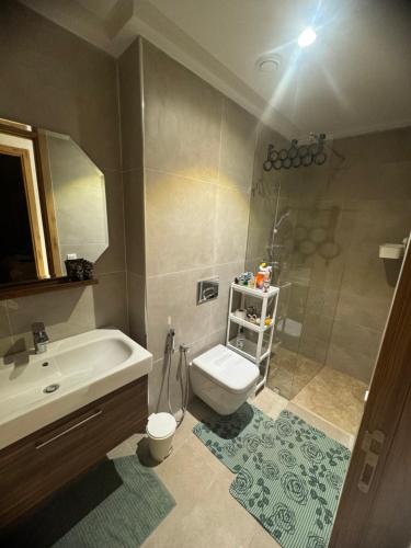 uma casa de banho com um lavatório, um WC e um chuveiro em Appartement luxe avec piscine Marrakech em Marrakech