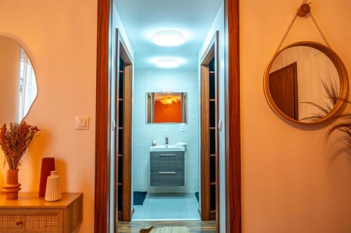 a bathroom with a sink and a mirror at Appartement Standing piscine intérieur privatisée . in Mutzig