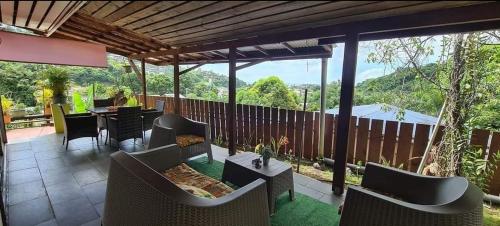 a patio with chairs and a table with a view at Tauraatini House F4 in Papeete