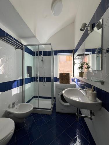a blue and white bathroom with two sinks and a shower at Casa Maria Rosa - seaside apartment in Sorrento
