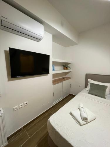 a bedroom with a flat screen tv on the wall at Cute studio near acropolis in Athens