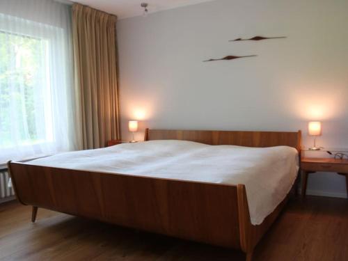 a bedroom with a large wooden bed and a desk at Landhuus Stender in Eutin