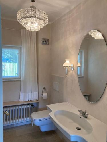 a bathroom with a sink and a mirror and a toilet at Landhuus Stender in Eutin