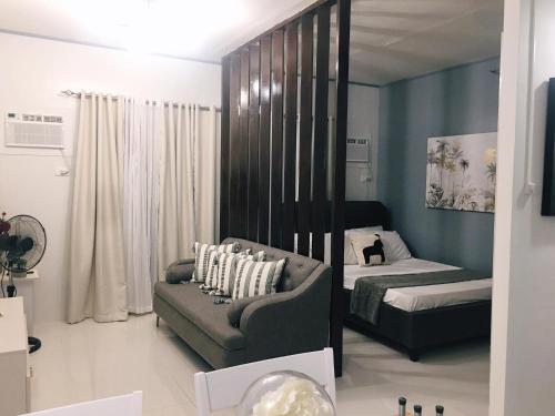 sala de estar con sofá y cama en Cozy Condo Palawan, en Puerto Princesa City