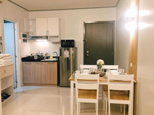 a kitchen with a table and chairs in a kitchen at Cozy Condo Palawan in Puerto Princesa City