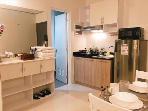 a kitchen with a refrigerator and a table in it at Cozy Condo Palawan in Puerto Princesa City