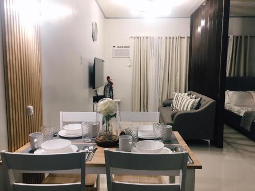 mesa de comedor con sillas y sala de estar. en Cozy Condo Palawan, en Puerto Princesa City