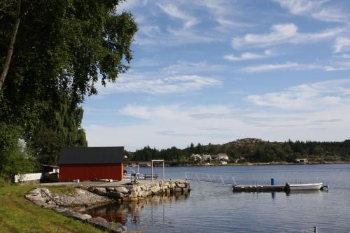 un muelle con un edificio rojo sobre el agua en Åkviktunet hytte Sør, en Averoy