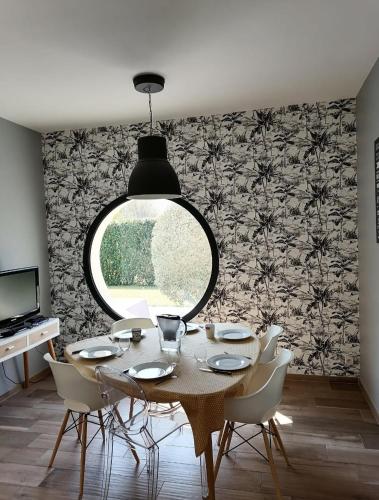 une salle à manger avec une table et une grande fenêtre dans l'établissement Maison contemporaine 230m2 Pegasus, à Bénouville