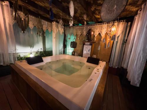 a bath tub in a room with curtains at Casa de Veraneio Villa Lopes in Bonfim