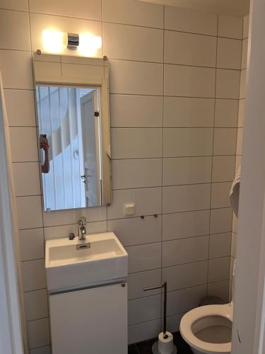La salle de bains est pourvue d'un lavabo, d'un miroir et de toilettes. dans l'établissement Rådhus, à Bara