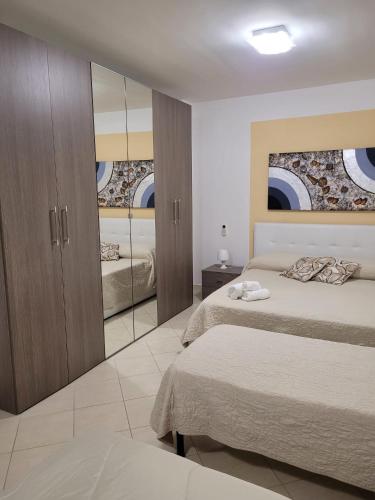 a bedroom with two beds and a mirror at Kristal in Cinisi