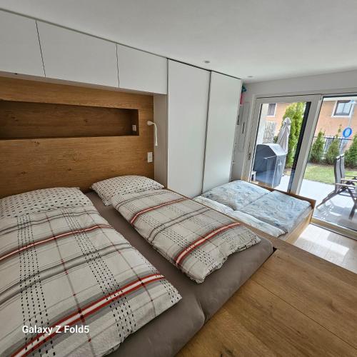 two beds in a room with a large window at Sonnenparadies in San Genesio Atesino