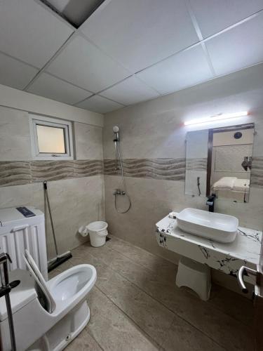 a bathroom with a sink and a toilet and a mirror at Comfortia Guest House 3 Bed with DringDining in Karachi