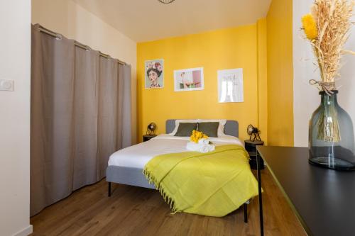 a bedroom with a bed with yellow walls and a table at Confort moderne à Marseille in Marseille