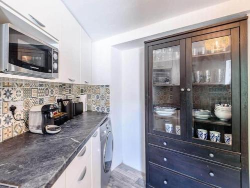 une cuisine avec un comptoir et une armoire avec de la vaisselle dans l'établissement Forest side cottage, à Nottingham
