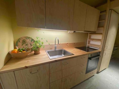 a kitchen with a sink and a bowl of fruit at House by the ocean in Halmstad