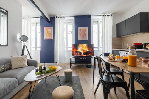 a living room with a couch and a table with a fireplace at Confort moderne à Marseille in Marseille