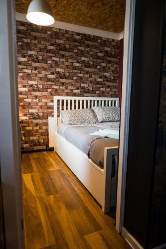 a bedroom with a bed and a brick wall at 2 Independant Boutique Apartments one sleeps 2 the other sleeps 4, Meadowhall, Sheffield Arena, Free Parking in Sheffield