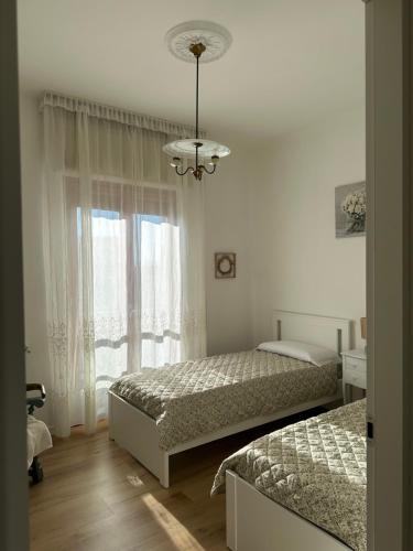 a bedroom with two beds and a window at Casa di Maya in Portacomaro