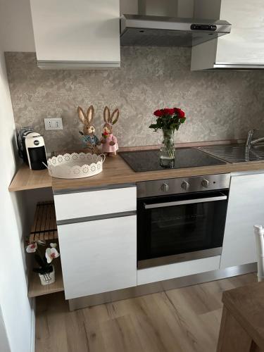 a kitchen with white cabinets and a black oven at Casa di Maya in Portacomaro