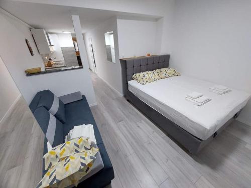 a small bedroom with a bed and a mirror at Apartman Amfora in Malinska