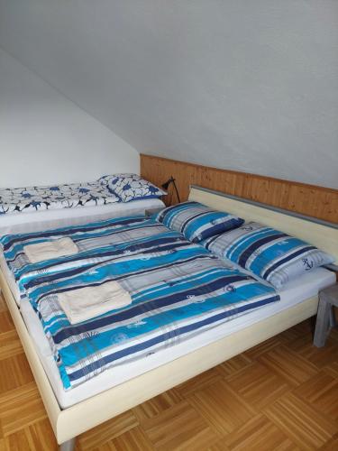 a bed with a blue and white blanket on it at Haus Jezek in Windischgarsten