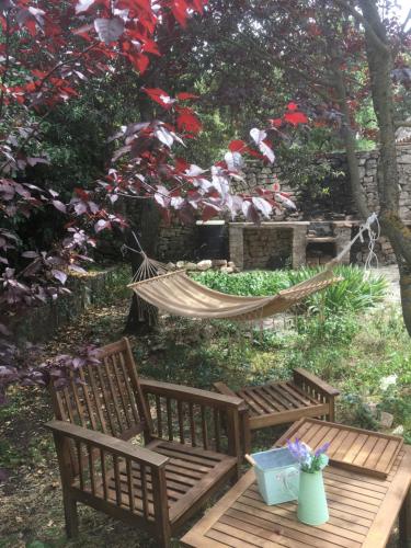 a hammock in a garden with two benches and a table at Masiadenjust in Rojals