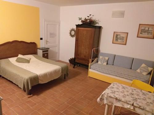 a bedroom with a bed and a couch in it at B&B Il vecchio pero in Capriglio