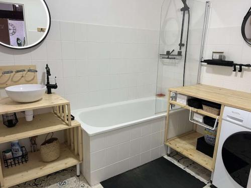 y baño con bañera y lavamanos. en Expérience Cocooning typé Loft en Braux