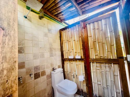 a bathroom with a toilet and a wooden door at The Tulum Vibe in Old Town PV in Puerto Vallarta