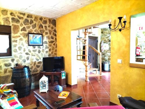 a living room with yellow walls and a tv at Casa do Terreiro in Cujó