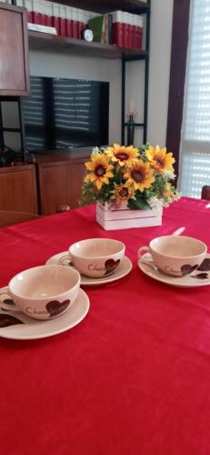 a table with two bowls and plates on a red table at Casa Angela Parma in Parma