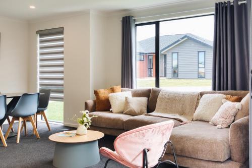 a living room with a couch and a table and chairs at Stylish 4 Bedroom house Brand New in Rotorua in Rotorua