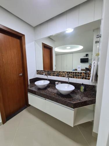 a bathroom with two sinks and a large mirror at 8-Flat confortável lugar nobre in Manaus